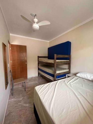 a bedroom with a bed and two bunk beds at Apartamento completo com wi-fi e piscina in Ubatuba