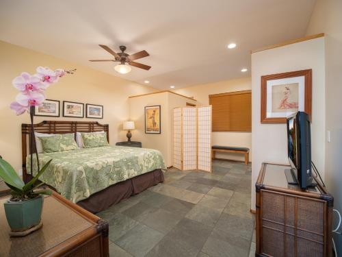 a bedroom with a bed and a flat screen tv at Aloha Aku Bamboo2 Suite - A Serene Retreat by the Shore in Kihei