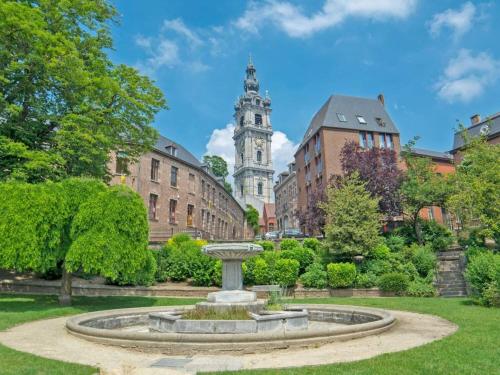 a fountain in the middle of a park with a clock tower at Forest Mansion Retreat in Antoing