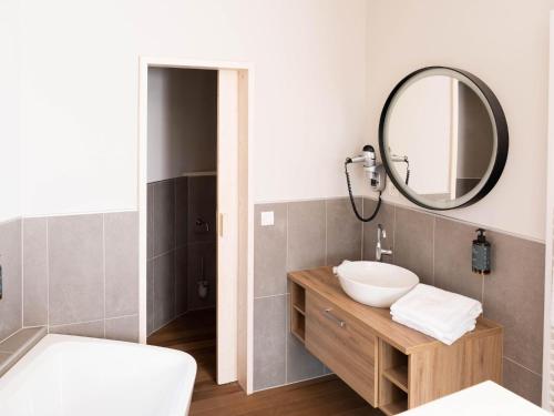 um banheiro com uma pia e um espelho em Cozy Bungalow & Shared Pools em Antoing