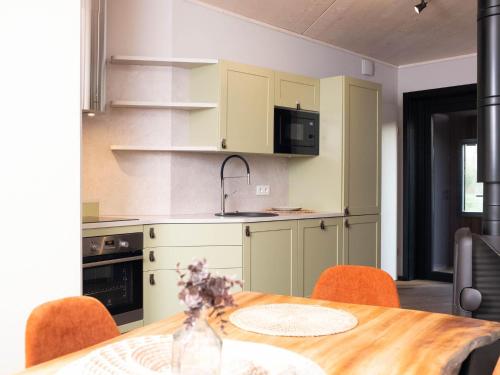 a kitchen with a wooden table with orange chairs at Relaxing Nature Getaway in Antoing