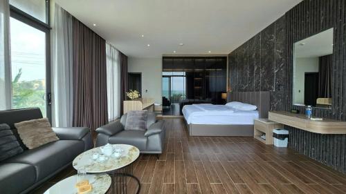 a bedroom with a bed and a living room at Villa Phong Thuỷ in Xóm Tram