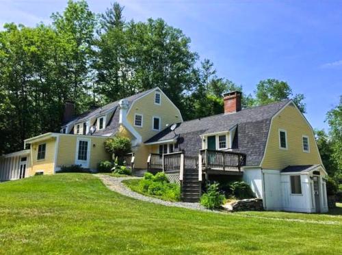 a large yellow house with a large yard at Private Tavern, Hot Tub, 8-Fireplaces, Spa Baths, Fire Pit, Baths Ensuite - Shop or Ski! in Landgrove Town Center