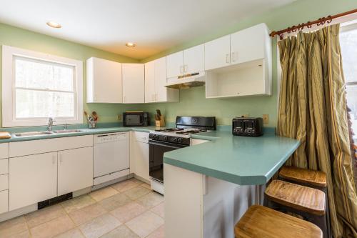 a kitchen with white cabinets and a blue counter top at Private Tavern, Hot Tub, 8-Fireplaces, Spa Baths, Fire Pit, Baths Ensuite - Shop or Ski! in Landgrove Town Center