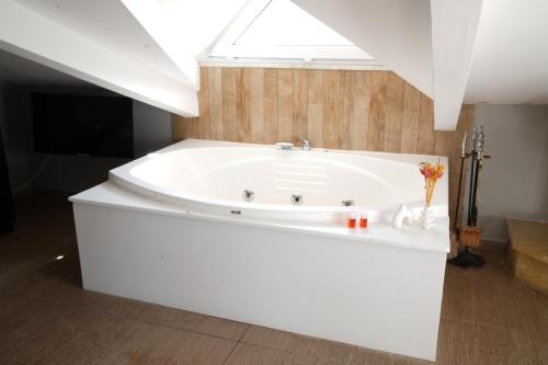 eine weiße Badewanne in einem Badezimmer mit Dachfenster in der Unterkunft BUTTERFLY BOUTIQUE HOTEL AĞVA in Sile