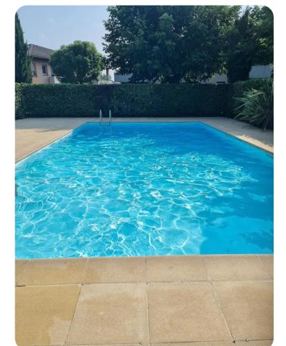 une piscine avec de l'eau bleue dans une cour dans l'établissement Escale marine, à Saint-Jory