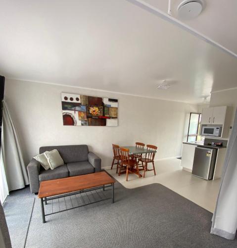 a living room with a couch and a table at Opononi Lighthouse Motel in Opononi
