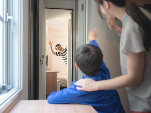 a woman and a child looking in a mirror at Super Hotel Sendaieki Higashiguchi Tennenonsen in Sendai