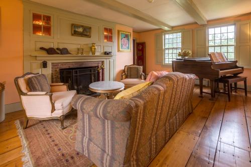 a living room with a couch and a piano at 100 percent Private! Pool, Views, Skiing, Theatre! in Weston