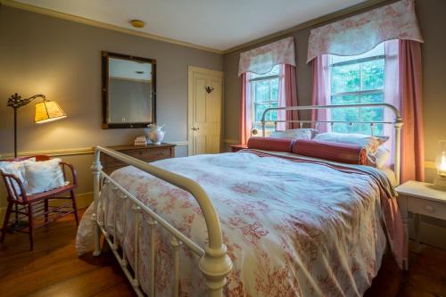 a bedroom with a bed and a mirror and a chair at 100 percent Private! Pool, Views, Skiing, Theatre! in Weston