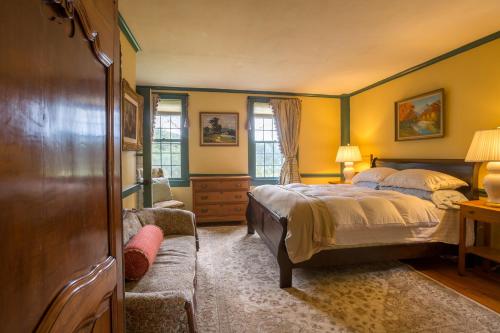 a bedroom with yellow walls and a bed and a couch at 100 percent Private! Pool, Views, Skiing, Theatre! in Weston
