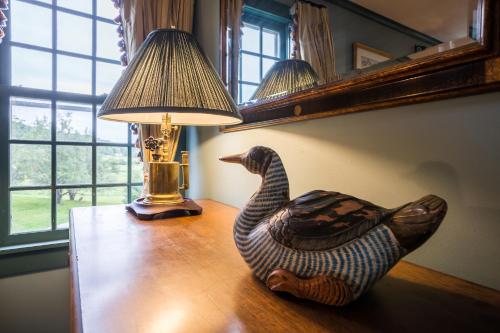a lamp and a wooden duck sitting on a table at 100 percent Private! Pool, Views, Skiing, Theatre! in Weston