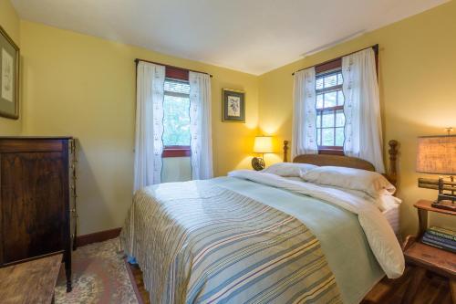 a bedroom with a bed and two windows at 100 percent Private! Pool, Views, Skiing, Theatre! in Weston