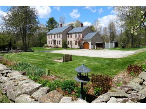 a large house with a stone wall in a yard at 100 percent Private! Pool, Views, Skiing, Theatre! in Weston