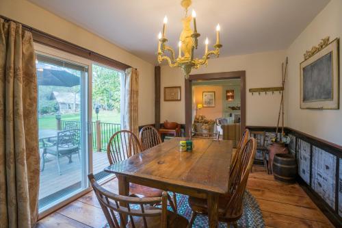 a dining room with a wooden table and chairs at Fireplace, Ski-Okemo, Apple Trees, Piano, Amazing Views, Firepit, Priory, Pool, Fields, Theatre! in Weston