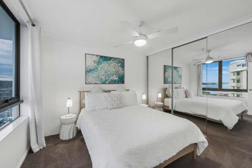 Un dormitorio blanco con dos camas y una ventana. en Pearl By Khove, en Gold Coast