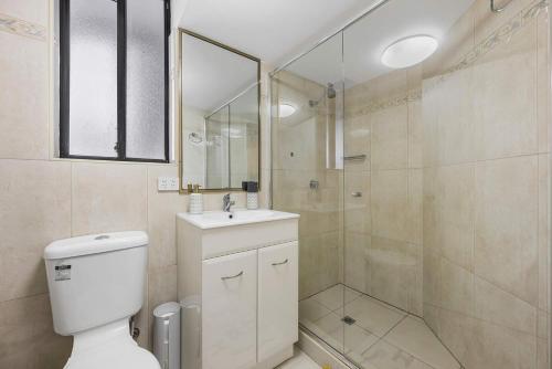 Un baño con ducha, inodoro y lavabo. en Pearl By Khove, en Gold Coast