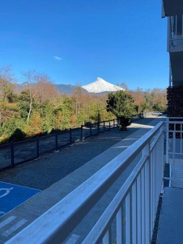 une passerelle avec une clôture et une montagne en arrière-plan dans l'établissement Departamento en Pucón con buena ubicación, à Pucón