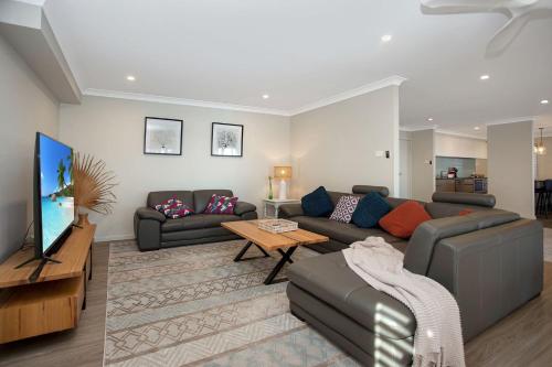 a living room with a couch and a tv at Keera House on Heros Bay in North Arm Cove