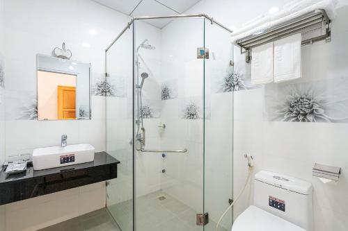 a bathroom with a shower and a toilet and a sink at Dalat Wind Hotel in Da Lat