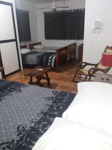 a room with two beds and two chairs in it at La Casa del Chac in Mérida