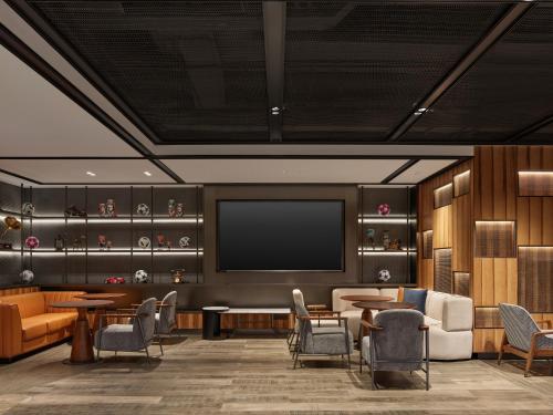 a waiting room with a tv and tables and chairs at Four Points by Sheraton Changzhou Economic Development Zone in Changzhou