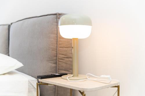 a lamp on a side table next to a bed at Oporto Charming Studio Gaia in Vila Nova de Gaia