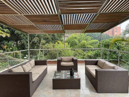 a patio with two couches and a coffee table at Palos altos house Poblado 6 min to Provenza in El Poblado