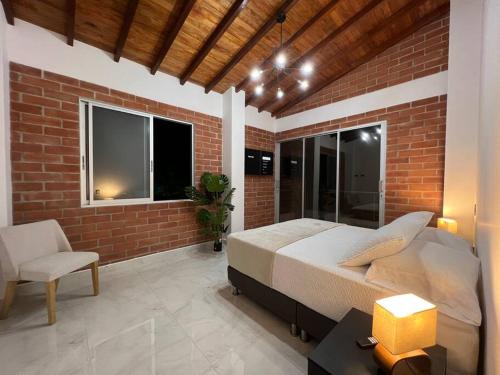 a bedroom with a bed and a brick wall at Palos altos house Poblado 6 min to Provenza in El Poblado