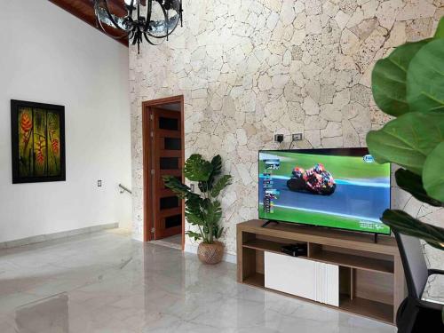 a living room with a flat screen tv on a stand at Palos altos house Poblado 6 min to Provenza in El Poblado