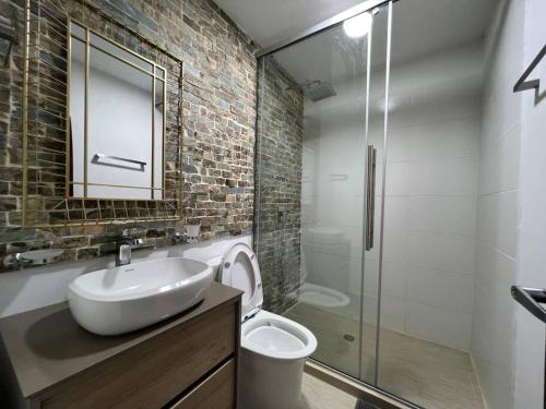 a bathroom with a sink and a glass shower at Palos altos house Poblado 6 min to Provenza in El Poblado