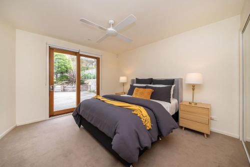a bedroom with a bed and a ceiling fan at Cedar Views in McCrae in McCrae