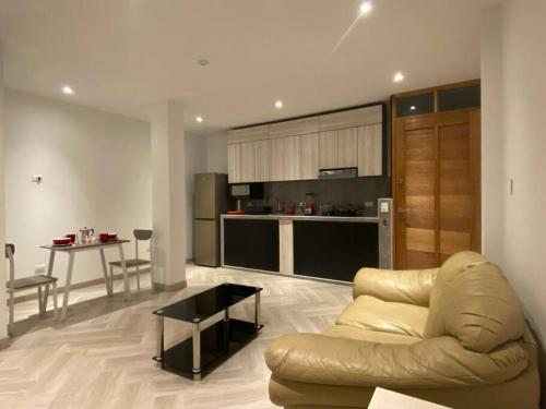 a living room with a couch and a kitchen at Moderno Apto Estudio 02 in Cajamarca
