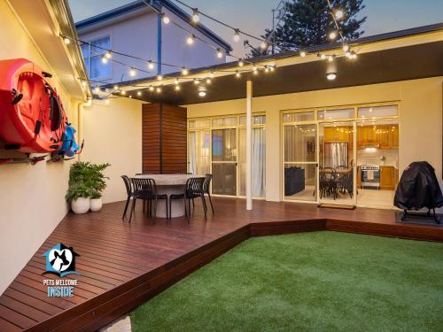 a patio with a table and chairs and a green rug at Seaspray Cottage Holiday Accommodation Victor Harbor in Victor Harbor
