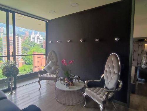 a living room with two chairs and a table at Class suites nirvana in El Poblado