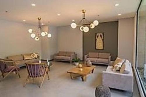 a large living room with couches and a chandelier at Class suites nirvana in El Poblado