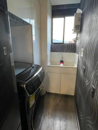 a small bathroom with a sink and a washing machine at Class suites nirvana in El Poblado