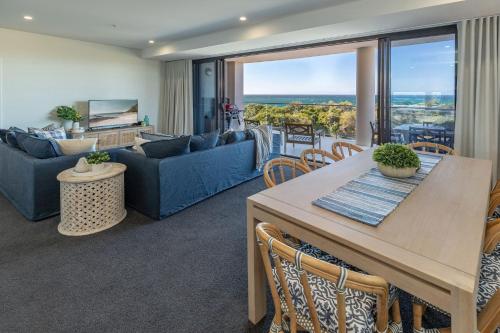 a living room with a blue couch and a table at Cove 701 in Forster