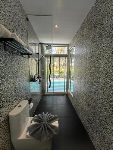 a bathroom with a toilet and a large window at ทิพย์วาริน รีสอร์ท เขาใหญ่ in Ban Tha Chang