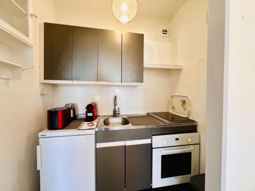 une petite cuisine avec un évier et une cuisinière dans l'établissement Studio rénové 30m² à Quiberon avec balcon et parking - FR-1-478-289, à Quiberon