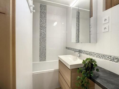 a white bathroom with a sink and a bath tub at Appartement rénové skis aux pieds, proche commerces, Courchevel 1650 - FR-1-563-157 in Courchevel