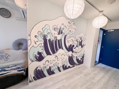 a room with a wave mural on the wall at 東京スカイツリー眺望 一棟貸切 駅徒歩50秒 浅草8分 スカイツリー4分 銀座20分 in Tokyo