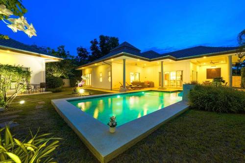 a house with a swimming pool at night at 4 Bedroom Private Pool Villa - MR51 in Hua Hin