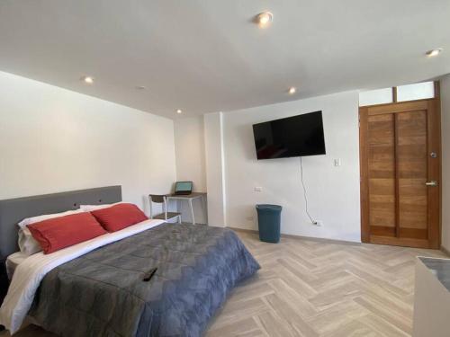 a bedroom with a bed and a flat screen tv at Estreno Apto Estudio 04 in Cajamarca
