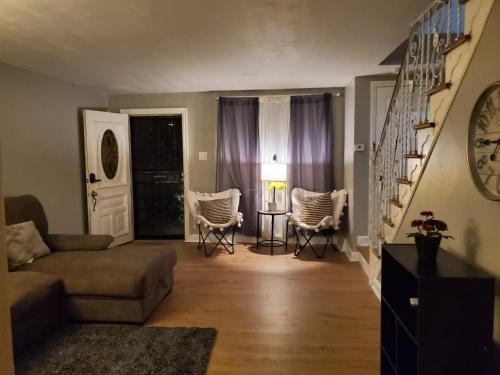 a living room with a couch and chairs and a table at Tranquility Room by the Airport -Shared space in Darby