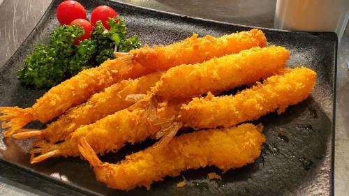 a plate of fried food with broccoli and tomatoes at Dormy Inn Premium Namba Natural Hot Spring in Osaka
