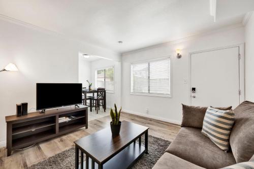 a living room with a couch and a flat screen tv at Cozy Elegant Oasis With Parking in Los Angeles