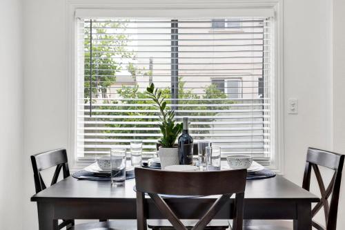 a dining room table with a potted plant in front of a window at Cozy Elegant Oasis With Parking in Los Angeles