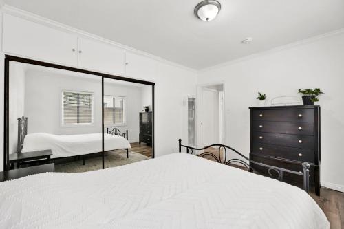 a bedroom with a bed and a dresser and a mirror at Cozy Elegant Oasis With Parking in Los Angeles