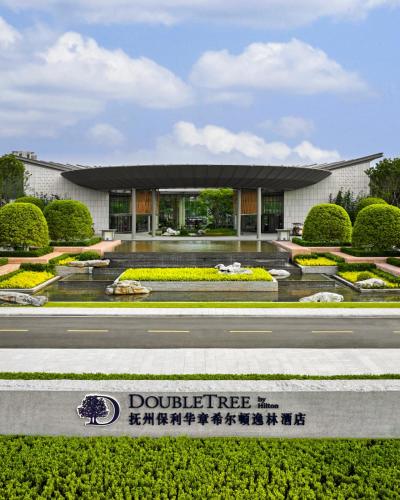 a building with a sign in front of it at DoubleTree by Hilton Jiangxi Fuzhou in Fuzhou